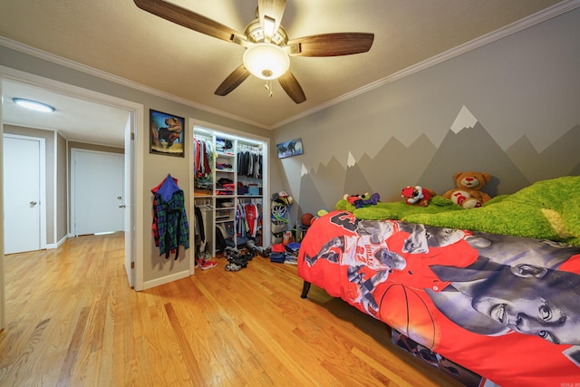 bedroom with light hardwood / wood-style floors, a closet, ornamental molding, and ceiling fan