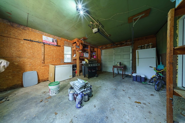 garage with white fridge and a garage door opener