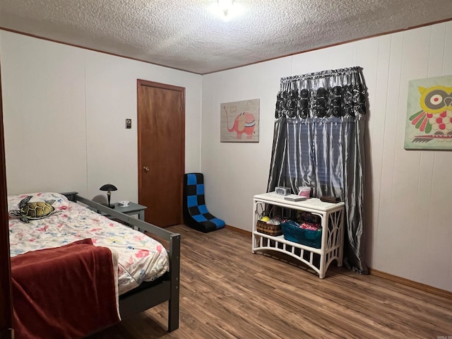 bedroom with hardwood / wood-style floors and a textured ceiling