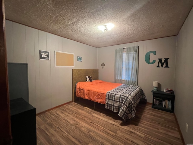 bedroom with hardwood / wood-style floors and a textured ceiling