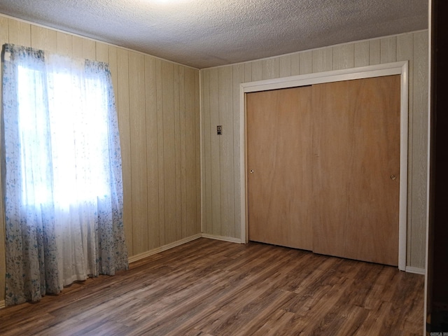 802 Casey St, Leslie, AR 72645 - spare room featuring wood finished floors, wood walls, and a textured ceiling