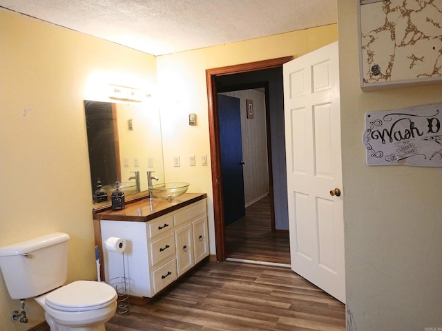 802 Casey St, Leslie, AR 72645 - bathroom featuring vanity, wood finished floors, toilet, and a textured ceiling