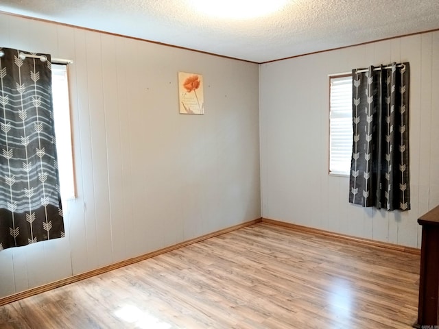802 Casey St, Leslie, AR 72645 - empty room featuring wood finished floors, crown molding, a textured ceiling, and baseboards