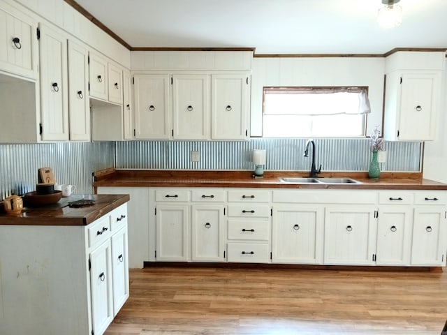 802 Casey St, Leslie, AR 72645 - kitchen with a sink, light wood-style floors, white cabinetry, ornamental molding, and wooden counters