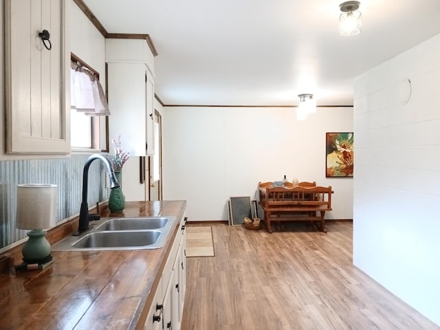 802 Casey St, Leslie, AR 72645 - kitchen featuring a sink, light wood-type flooring, white cabinets, wood counters, and crown molding