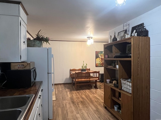 kitchen with sink, white cabinets, and hardwood / wood-style flooring