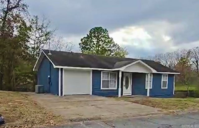 ranch-style house with central AC unit and a garage