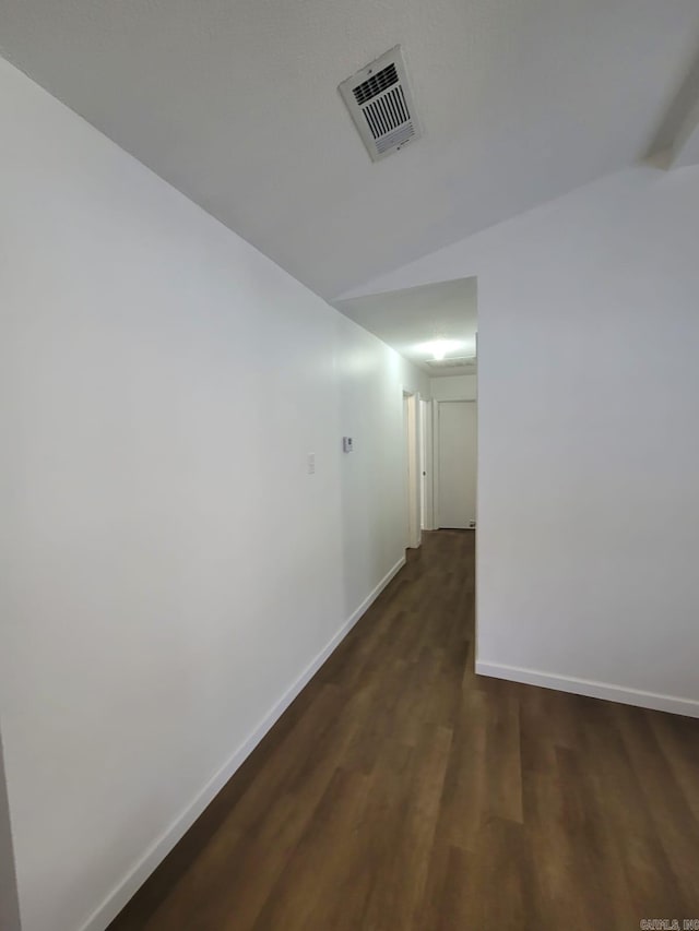 hallway featuring dark hardwood / wood-style flooring and lofted ceiling