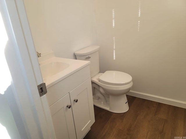 bathroom featuring vanity, wood-type flooring, and toilet