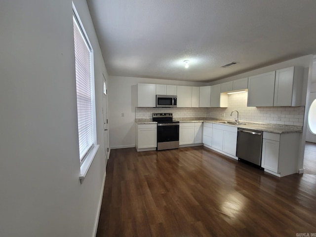 kitchen with white cabinetry, sink, dark hardwood / wood-style floors, and appliances with stainless steel finishes