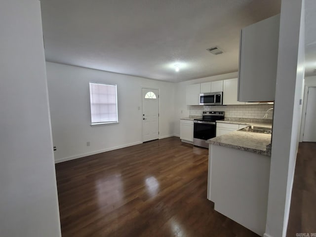 kitchen featuring sink, tasteful backsplash, dark hardwood / wood-style flooring, white cabinetry, and stainless steel appliances