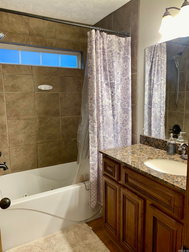 bathroom featuring vanity, a textured ceiling, and shower / tub combo