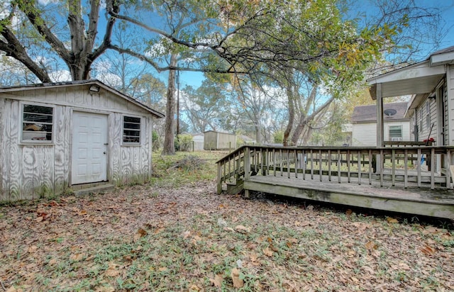 view of yard featuring a storage unit and a wooden deck