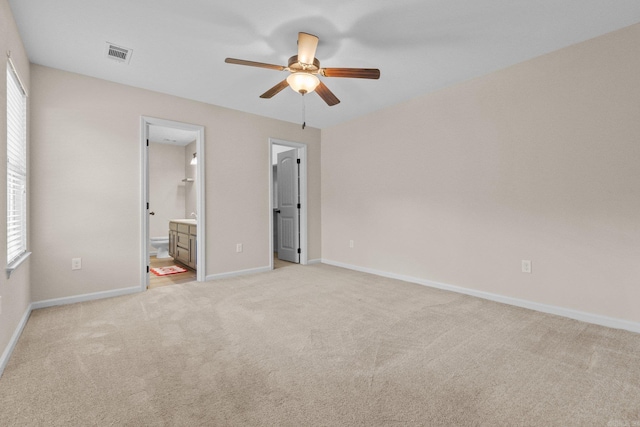 unfurnished bedroom with light carpet, ensuite bathroom, and ceiling fan