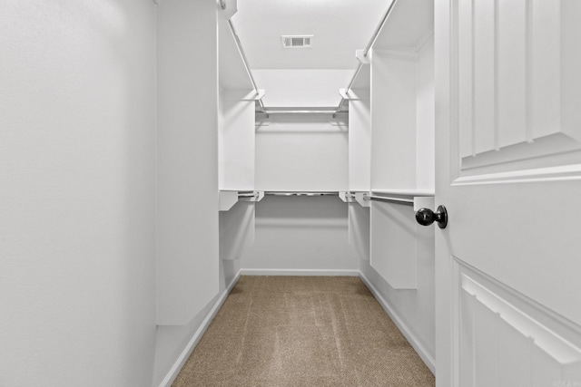 walk in closet featuring light carpet