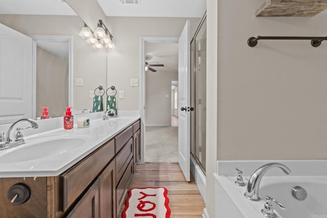 bathroom featuring hardwood / wood-style flooring, vanity, ceiling fan, and a tub