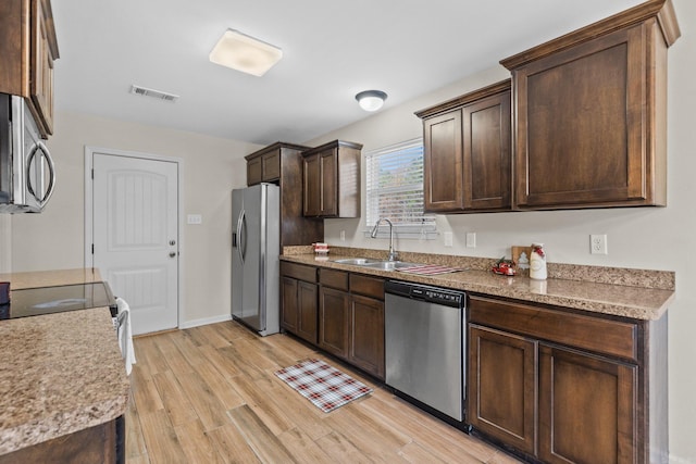 kitchen with light hardwood / wood-style flooring, stainless steel appliances, dark brown cabinets, and sink