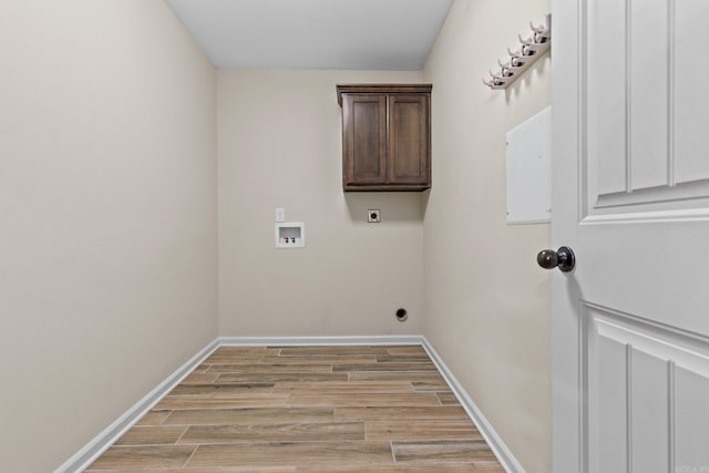 laundry area featuring electric dryer hookup, cabinets, light wood-type flooring, and hookup for a washing machine