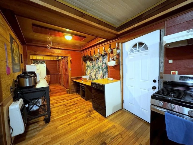 kitchen featuring heating unit, wooden walls, light hardwood / wood-style flooring, dishwasher, and stainless steel range with gas stovetop