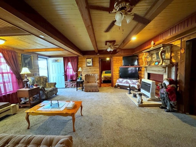 carpeted living room with beamed ceiling, ceiling fan, wood walls, and heating unit