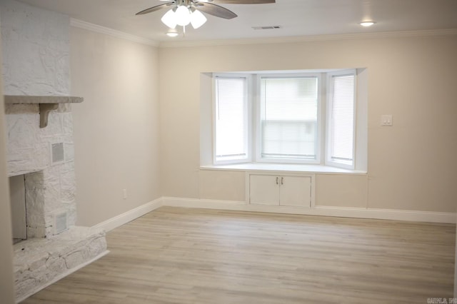 unfurnished living room featuring a stone fireplace, ceiling fan, light hardwood / wood-style floors, and ornamental molding