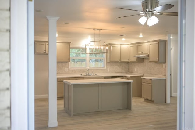 kitchen with gray cabinets, a center island, tasteful backsplash, and light hardwood / wood-style flooring