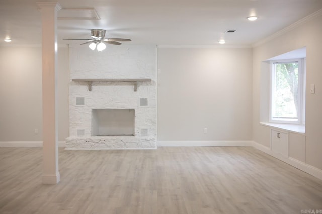 unfurnished living room featuring light hardwood / wood-style flooring, ceiling fan, crown molding, and a stone fireplace