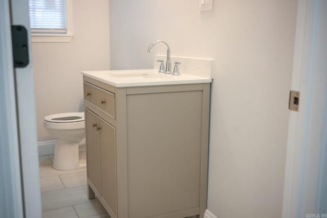 bathroom with tile patterned flooring, vanity, and toilet