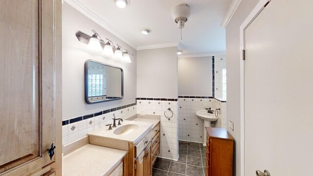 bathroom featuring tile patterned flooring, double sink, ornamental molding, and tile walls