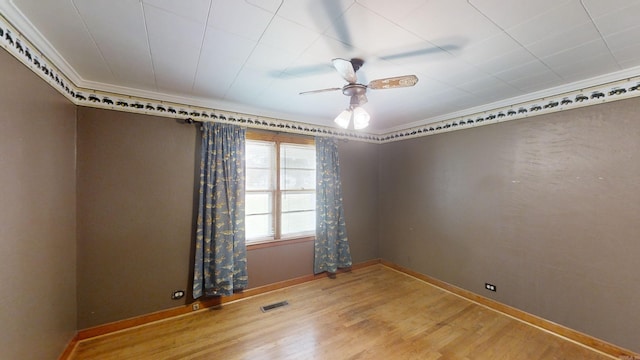 spare room featuring hardwood / wood-style floors, ceiling fan, and ornamental molding