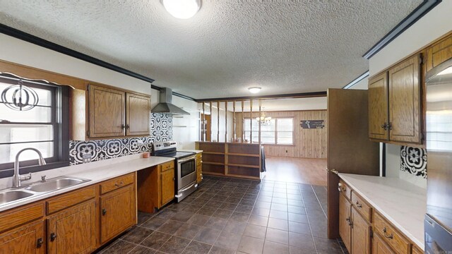 kitchen featuring stainless steel range with electric stovetop, pendant lighting, sink, wall chimney exhaust hood, and a textured ceiling