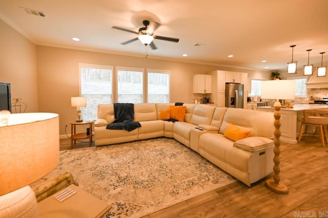 living room with ceiling fan, hardwood / wood-style floors, and ornamental molding