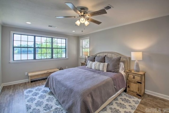 bedroom featuring ceiling fan, crown molding, and dark wood-type flooring