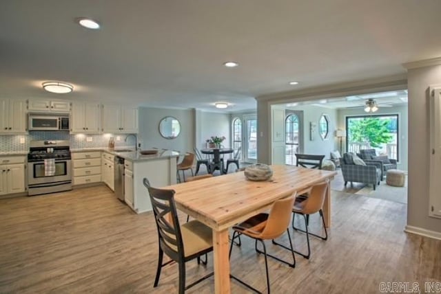 dining room with ceiling fan, light hardwood / wood-style flooring, crown molding, and sink