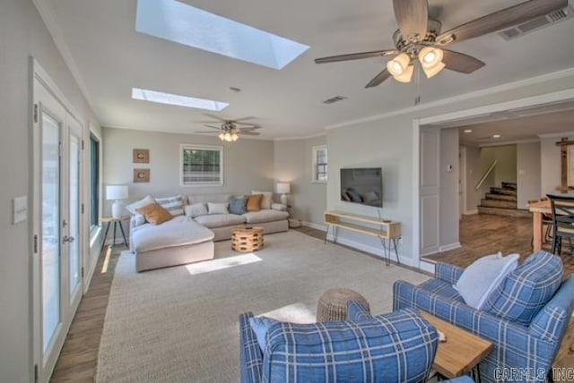 living room featuring ceiling fan, light hardwood / wood-style floors, and crown molding