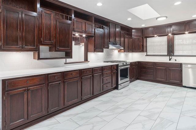 kitchen featuring a skylight, sink, stainless steel appliances, tasteful backsplash, and dark brown cabinets