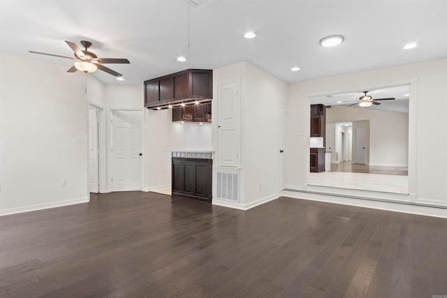 unfurnished living room featuring dark hardwood / wood-style flooring and ceiling fan