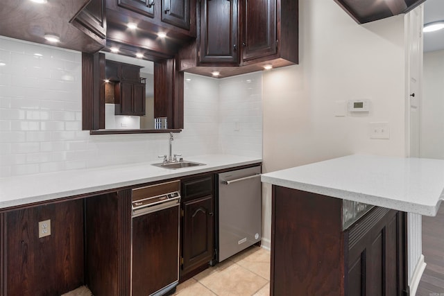 kitchen with backsplash, stainless steel dishwasher, dark brown cabinetry, sink, and light tile patterned floors