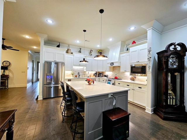 kitchen featuring pendant lighting, white cabinetry, stainless steel appliances, and dark wood-type flooring