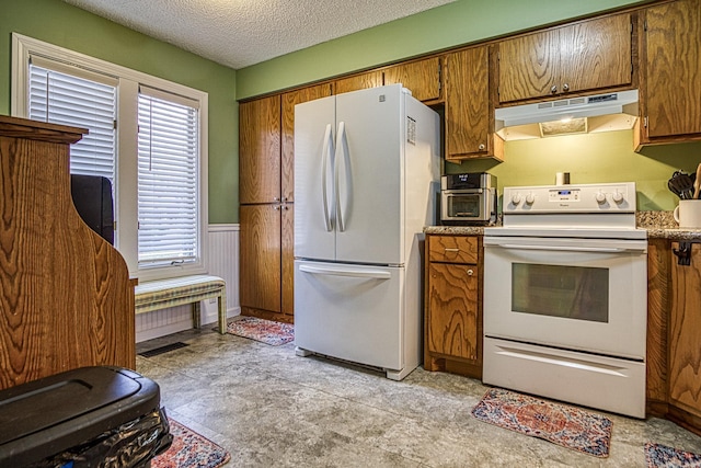 kitchen with a textured ceiling and white appliances