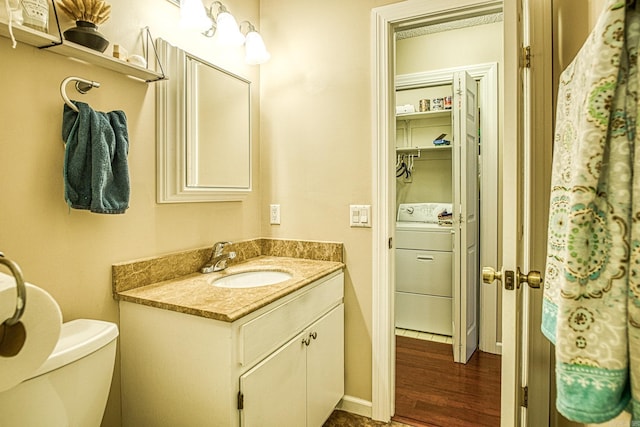 bathroom featuring washer / clothes dryer, vanity, wood-type flooring, and toilet