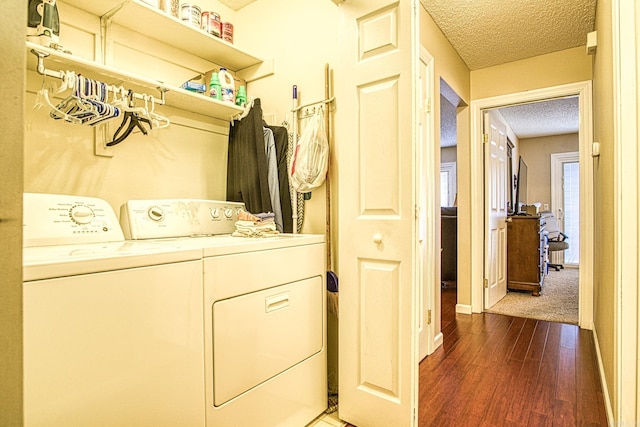 laundry area featuring a textured ceiling, washer and clothes dryer, and dark wood-type flooring