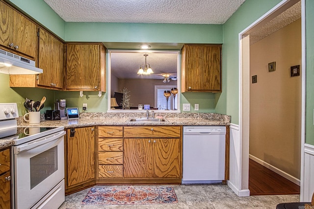 kitchen with sink, a notable chandelier, a textured ceiling, decorative light fixtures, and white appliances