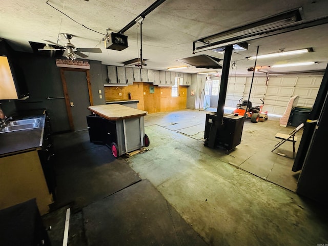 garage with a garage door opener, ceiling fan, and sink