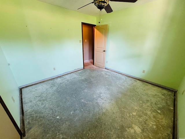 unfurnished room with ceiling fan, concrete flooring, and a textured ceiling