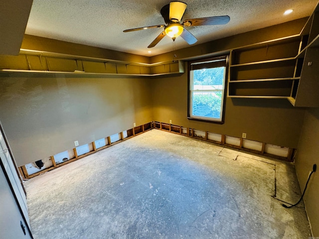 empty room featuring concrete flooring, a textured ceiling, and ceiling fan