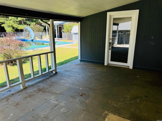 view of patio featuring a fenced in pool and a storage shed