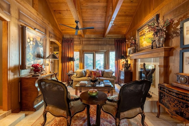 living area featuring vaulted ceiling with beams, ceiling fan, wooden ceiling, and wooden walls