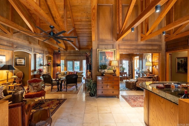 interior space with wooden walls, beam ceiling, wooden ceiling, and high vaulted ceiling