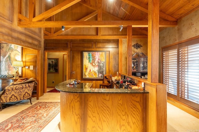 bar with wooden ceiling, high vaulted ceiling, dark stone counters, light tile patterned floors, and beam ceiling